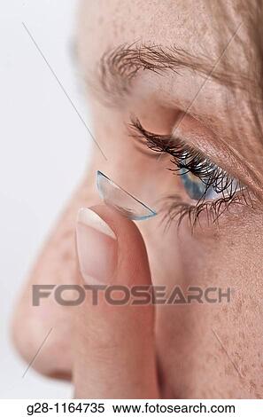young woman puttig in her contact lenses ( detail) View Large Photo Image Stock Photography - young woman puttig in her contact lenses ( detail). Fotosearch