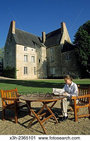 Stock Image - "young woman reading in the garden of Chateau de Sache, where the French writer Honore de Balzac wrote between 1825 and 1848 some of his finest works in the series La Comedie Humaine, Indre-et-Loire department, Centre region, France, Europe. ". Fotosearch