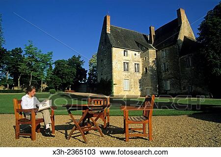 Stock Image - "young woman reading in the garden of Chateau de Sache, where the French writer Honore de Balzac wrote between 1825 and 1848 some of his finest works in the series La Comedie Humaine, Indre-et-Loire department, Centre region, France, Europe. ". Fotosearch