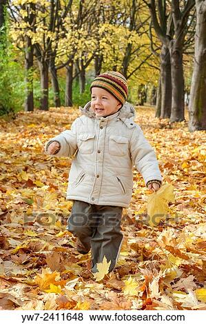 Stock Photo - "2 year old boy running in a park full of autumn leaves, Pole Mokotowskie, Warsaw, Poland. ". Fotosearch