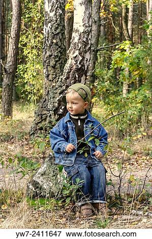 Stock Photo - "2 year old boy sitting on a tree trunk in Kampinos National Park, Poland. ". Fotosearch