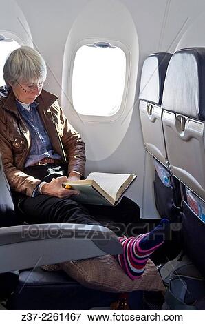 "A mature woman reads a book on board a flight, Ontario, Canada" View Large Photo Image Stock Photo - "A mature woman reads a book on board a flight, Ontario, Canada". Fotosearch