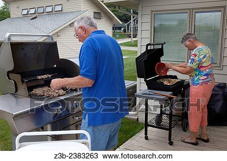"A senior couple barbeques at their home on Sanford Lake, Michigan, USA. " View Large Photo Image Stock Image - "A senior couple barbeques at their home on Sanford Lake, Michigan, USA. ". Fotosearch