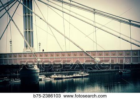 "Albert Bridge view with a woman walking, with boats moored at the Chelsea Harbour, London, England, UK. " View Large Photo Image Stock Image - "Albert Bridge view with a woman walking, with boats moored at the Chelsea Harbour, London, England, UK. ". Fotosearch