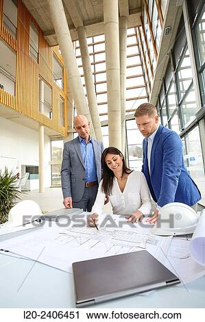 Architects looking at blueprints View Large Photo Image Stock Image - Architects looking at blueprints. Fotosearch