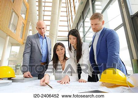 Architects looking at blueprints View Large Photo Image Stock Image - Architects looking at blueprints. Fotosearch