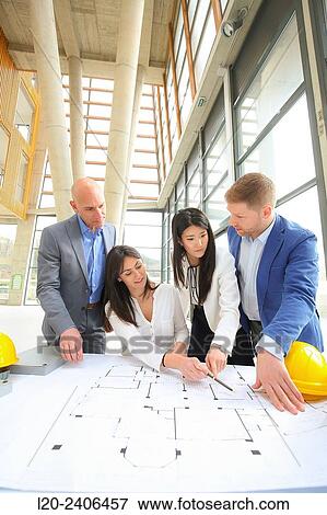 Stock Photo - Architects looking at blueprints. Fotosearch