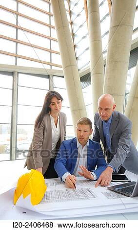 Architects looking at blueprints View Large Photo Image Stock Photo - Architects looking at blueprints. Fotosearch