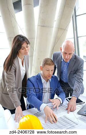 Architects looking at blueprints View Large Photo Image Stock Photo - Architects looking at blueprints. Fotosearch