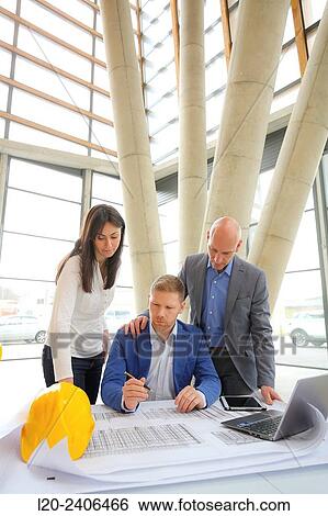 Architects looking at blueprints View Large Photo Image Stock Photograph - Architects looking at blueprints. Fotosearch