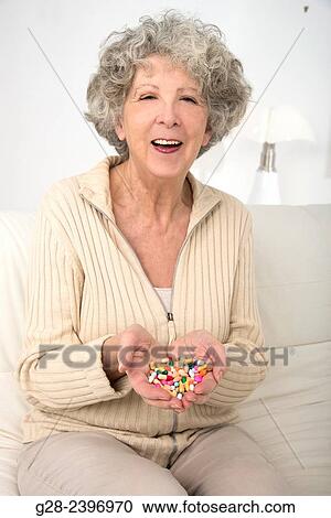 Beautiful surprised senior woman holding colorful tablets in her hands and laughing View Large Photo Image Stock Image - Beautiful surprised senior woman holding colorful tablets in her hands and laughing. Fotosearch