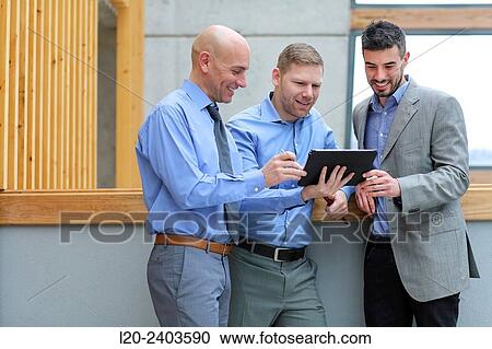 Stock Image - Business men looking at tablet. Fotosearch