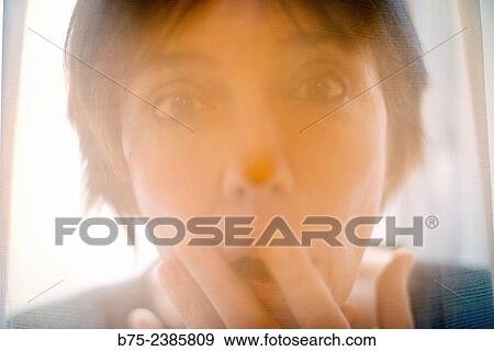 "Closeup of the face of a woman with hand in front of her mouth and surprised expression, behind a transparent curtain. " View Large Photo Image Stock Photo - "Closeup of the face of a woman with hand in front of her mouth and surprised expression, behind a transparent curtain. ". Fotosearch