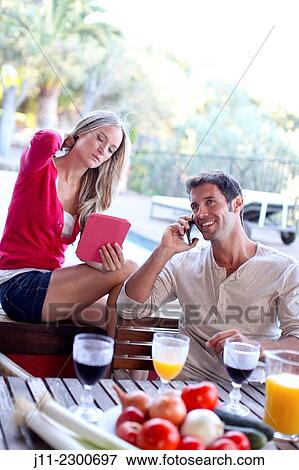 Couple with cell phone and digital tablet View Large Photo Image Stock Photo - Couple with cell phone and digital tablet. Fotosearch
