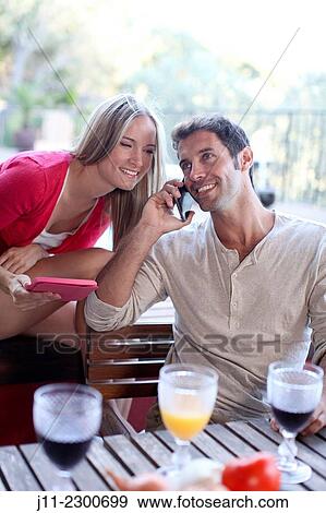 Stock Photo - Couple with cell phone and digital tablet. Fotosearch