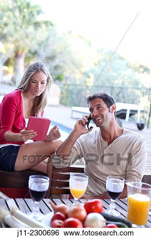 Stock Photograph - Couple with cell phone and digital tablet. Fotosearch