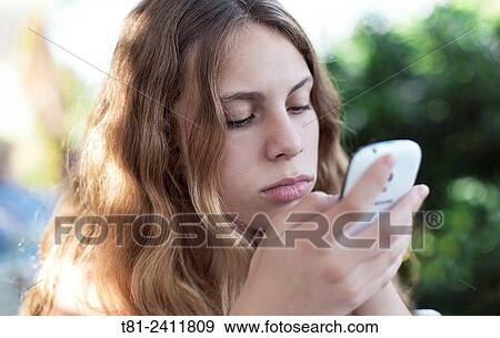 Stock Photo - "girl looking at a mobile phone in Benidorm, Spain". Fotosearch