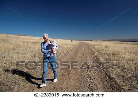Stock Photography - "Golden, Colorado - Susan Newell, 66, carries her grandson, Adam Hjermstad Jr., while hiking on North Table Mountain, a mesa above Denver which is designated an ""open space. "". ". Fotosearch