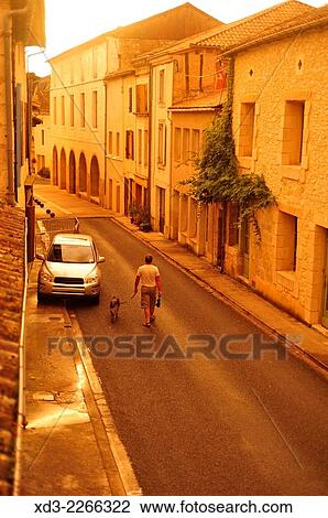 "man walking dog on Rue Taillefer as storm cleared, Lauzun, Lot-et-Garonne Department, Aquitaine, France. " View Large Photo Image Stock Image - "man walking dog on Rue Taillefer as storm cleared, Lauzun, Lot-et-Garonne Department, Aquitaine, France. ". Fotosearch
