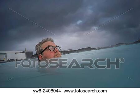 Picture - "Man wearing glasses in the Blue Lagoon, geothermal bathing hot springs, Iceland. ". Fotosearch