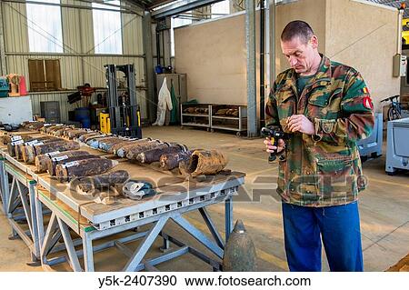 Stock Image - "Poelkapelle, Belgium. Army Battalion for Demolition of Explosives. Army chief corporal working on the identification and classification of recovered live World War 1 shells and munition, prior to demolition. ". Fotosearch