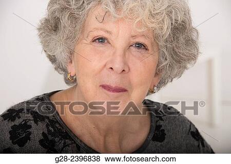 Stock Photo - Portrait of a beautiful senior woman smiling and looking at the camera. Fotosearch
