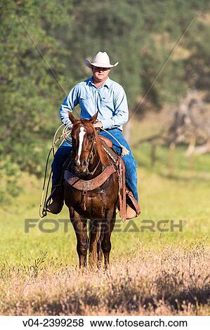 Stock Photo - "Single wrangler cowboy on horse, California, USA". Fotosearch