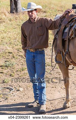 "Single wrangler cowboy standing next to his horse, California, USA" View Large Photo Image Stock Image - "Single wrangler cowboy standing next to his horse, California, USA". Fotosearch