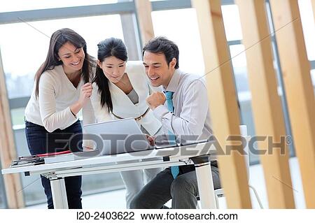 Stock Image - Three executives looking at computer. Fotosearch