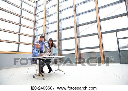 Stock Photo - Three executives looking at computer. Fotosearch
