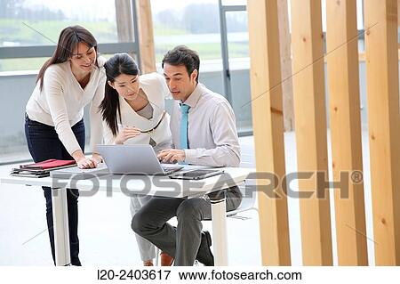 Three executives looking at computer View Large Photo Image Stock Photo - Three executives looking at computer. Fotosearch