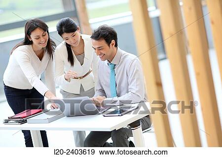 Stock Photo - Three executives looking at computer. Fotosearch