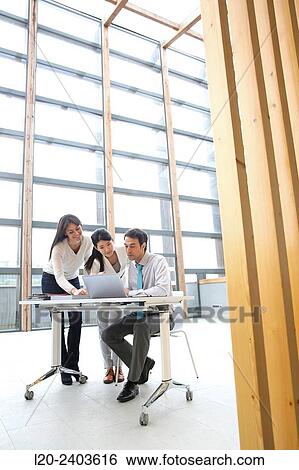 Three executives looking at computer View Large Photo Image Stock Photograph - Three executives looking at computer. Fotosearch