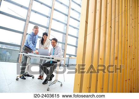 Three executives looking at computer View Large Photo Image Stock Photography - Three executives looking at computer. Fotosearch