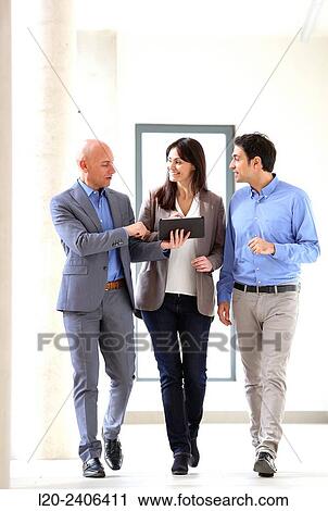Three executives looking at tablet View Large Photo Image Stock Image - Three executives looking at tablet. Fotosearch