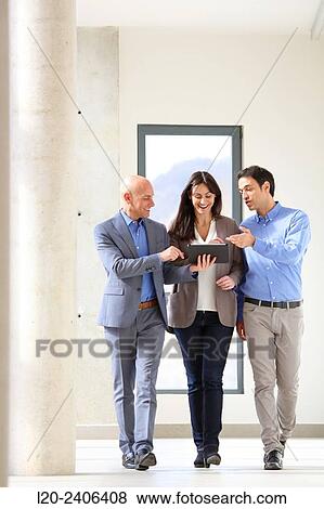 Three executives looking at tablet View Large Photo Image Stock Photo - Three executives looking at tablet. Fotosearch