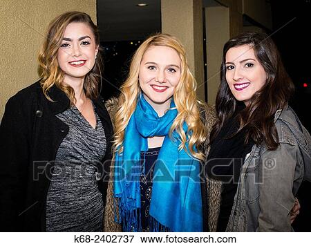 Stock Photo - "Three teenage girls smiling, ready to go out for an evening. ". Fotosearch