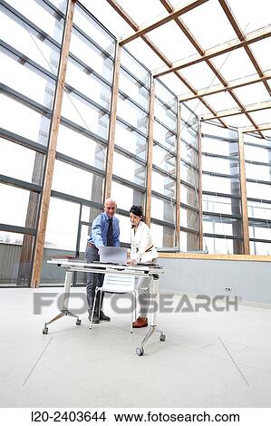 Picture - Two executives looking at laptop computer. Fotosearch