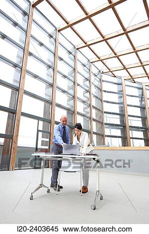 Two executives looking at laptop computer View Large Photo Image Stock Photography - Two executives looking at laptop computer. Fotosearch