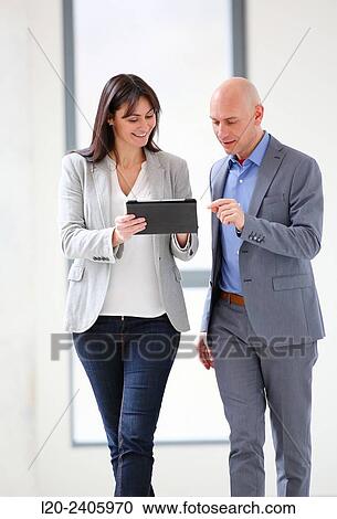 Two executives looking at tablet View Large Photo Image Stock Image - Two executives looking at tablet. Fotosearch