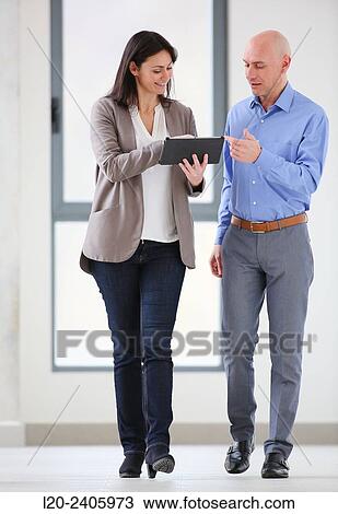 Two executives looking at tablet View Large Photo Image Stock Image - Two executives looking at tablet. Fotosearch