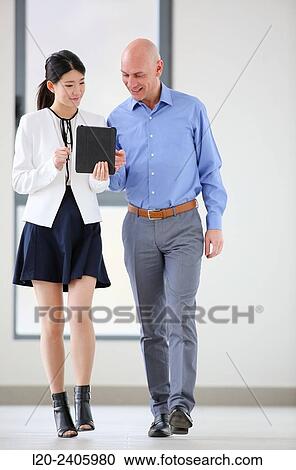 Two executives looking at tablet View Large Photo Image Stock Image - Two executives looking at tablet. Fotosearch