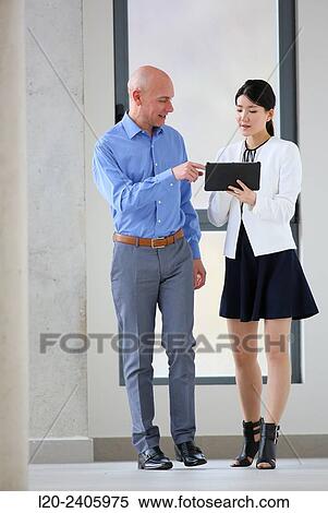 Two executives looking at tablet View Large Photo Image Stock Photography - Two executives looking at tablet. Fotosearch