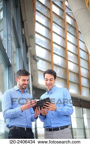 Two executives with digital tablet View Large Photo Image Picture - Two executives with digital tablet. Fotosearch