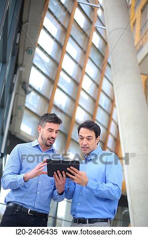 Two executives with digital tablet View Large Photo Image Stock Photography - Two executives with digital tablet. Fotosearch