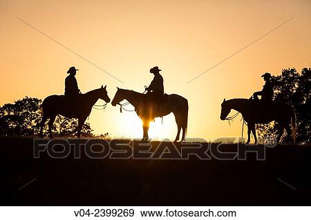 Stock Photo - "Two wranglers cowboys on horses at sunset, California, USA". Fotosearch