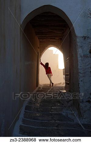 Stock Photo - "Woman by the archway in town center Chora, Ios, Cyclades Islands, Greek Islands, Greece, Europe. ". Fotosearch