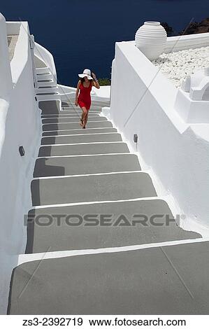 "Woman climbing up the stairs in Oia town, Santorini, Cyclades Islands, Greek Islands, Greece, Europe. " View Large Photo Image Stock Photo - "Woman climbing up the stairs in Oia town, Santorini, Cyclades Islands, Greek Islands, Greece, Europe. ". Fotosearch