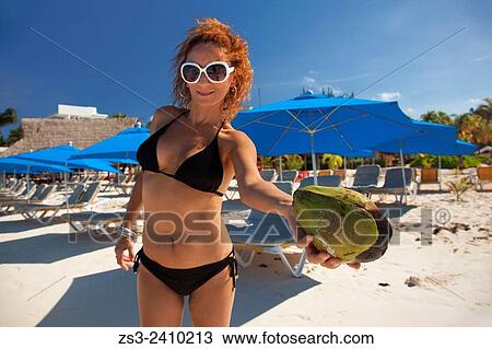 "Woman holding a coco nut on the beach, Isla Mujeres, Cancun, Quintana Roo, Yucatan Province, Mexico, Central America. " View Large Photo Image Stock Image - "Woman holding a coco nut on the beach, Isla Mujeres, Cancun, Quintana Roo, Yucatan Province, Mexico, Central America. ". Fotosearch