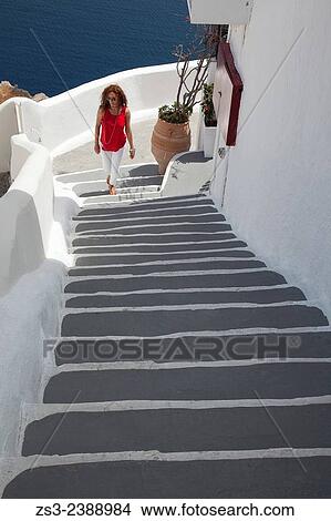 "Woman walking up the stairs in town center, Oia, Santorini, Cyclades Islands, Greek Islands, Greece, Europe. " View Large Photo Image Picture - "Woman walking up the stairs in town center, Oia, Santorini, Cyclades Islands, Greek Islands, Greece, Europe. ". Fotosearch